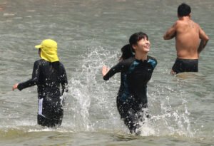 On the 29th, when a heat wave warning was issued in the eastern part of Jeju Island and a heat wave warning was issued between the north and the middle of the mountain, vacationers are enjoying the summer atmosphere by playing in the water or taking in the sea breeze at Hamdeok Beach in Jocheon-eup, Jeju-si. [Photo source = Yonhap News]