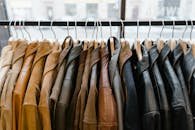 A collection of leather and suede jackets hanging on a clothes rack in a stylish boutique.