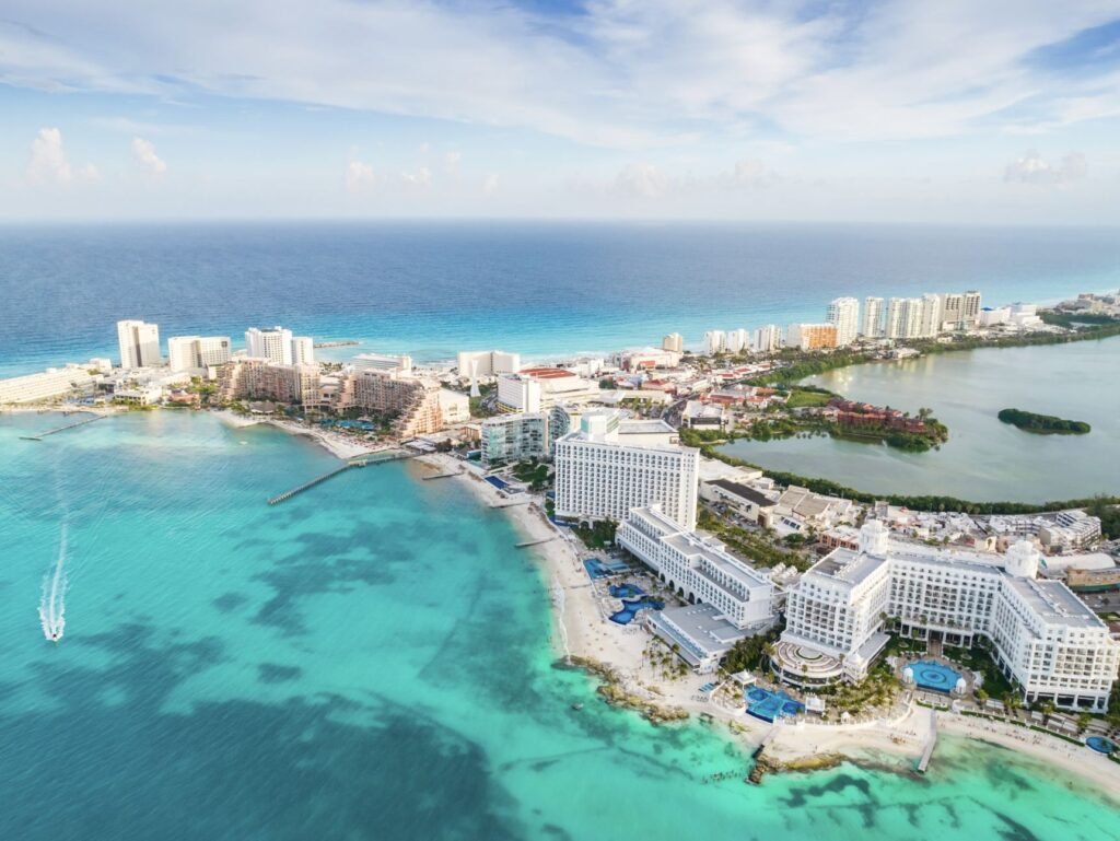 Aerial panoramic view of Cancun beach and city hotel zone in Mexico. Caribbean coast landscape of Mexican resort with beach Playa Caracol and Kukulcan road.