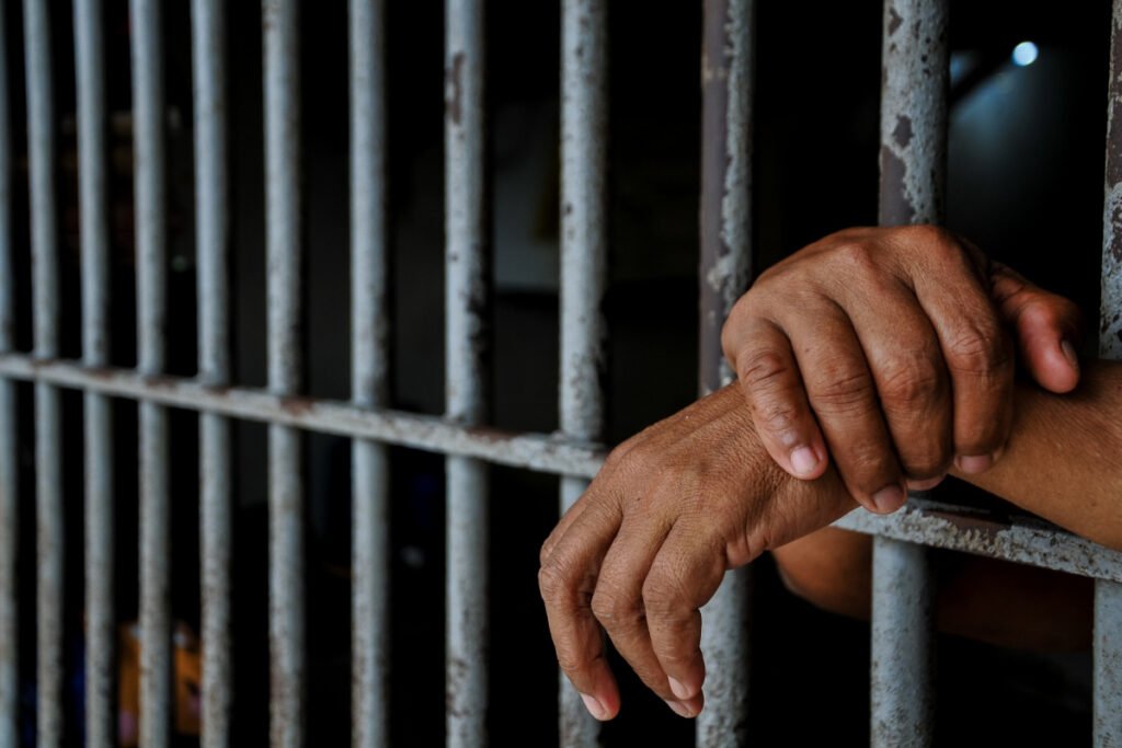 Jail Prison Hands Between Bars.jpg