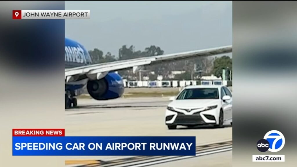 Car speeds by planes on runway at John Wayne Airport in Orange County, video shows