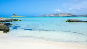 Italy's Best Beach In 2026 Has Shallow Caribbean-Blue Waters Perfect For Swimming And Windsurfing