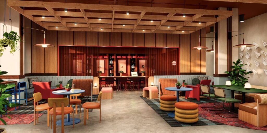 Modern co-working space with wooden ceiling grid, mixed seating including chairs, stools, and booths, and decorative plants.